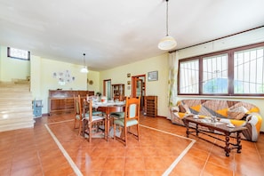 A spacious living area with a dining table, chairs, a sofa, and a staircase. - Villa Mattalia 500m From Sea (Manduria)