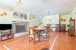Un comedor con chimenea, televisor y una mesa de comedor con sillas.
