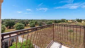 A balcony with a view of olive trees and distant buildings. - Villa Mattalia 500m From Sea (Manduria)
