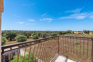 A balcony with a view of olive trees and distant buildings. - Villa Mattalia 500m From Sea (Manduria)