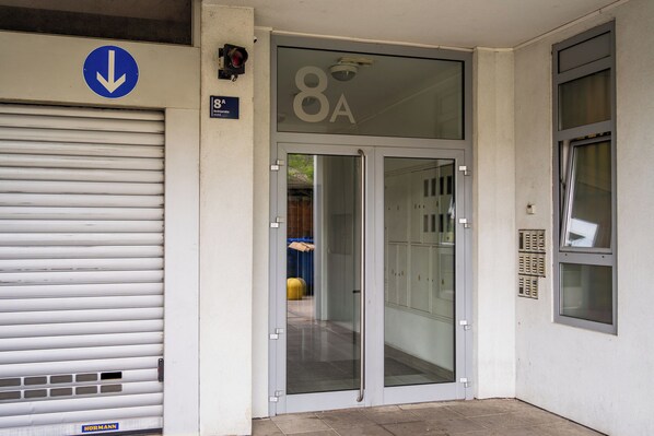 A building entrance with a glass door marked "8A" and a blue directional sign above it.