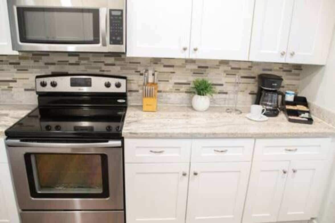 A kitchen with a microwave, stove, and cabinets.