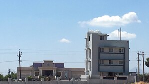 Un edificio de varios pisos con techo plano y una entrada central.