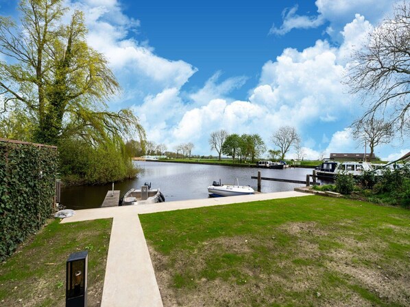 Enjoy serene views of the canal from this riverside retreat, surrounded by lush greenery and a well-manicured lawn.