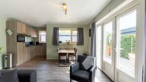 A modern kitchen with a dining area, large windows, and a cozy seating area. - Beautiful holiday home in Bantega with boat (Friesland)