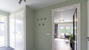 A hallway with a door leading to a balcony, a wall-mounted light fixture, and a doorbell. - Beautiful holiday home in Bantega with boat (Friesland)