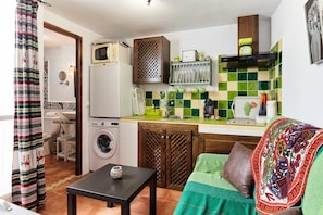 Cocina compacta con lavadora, microondas y fregadero.