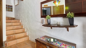 A staircase with wooden steps, a wall-mounted mirror, and a small table with a decorative cloth. - Apartment 'Guadalentin' with Private Terrace, Wi-Fi and Air Conditioning (Quesada)
