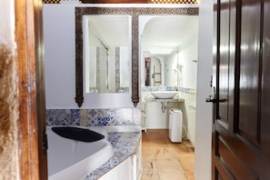 A bathroom with a bathtub, a sink, and a mirror. - Holiday Home 'Cazorla Rural Gualay' with Mountain View, Wi-Fi and Air Conditioning (QUESADA)