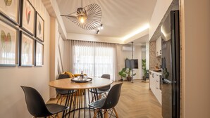 A modern dining area with a round table, black chairs, and a pendant light.