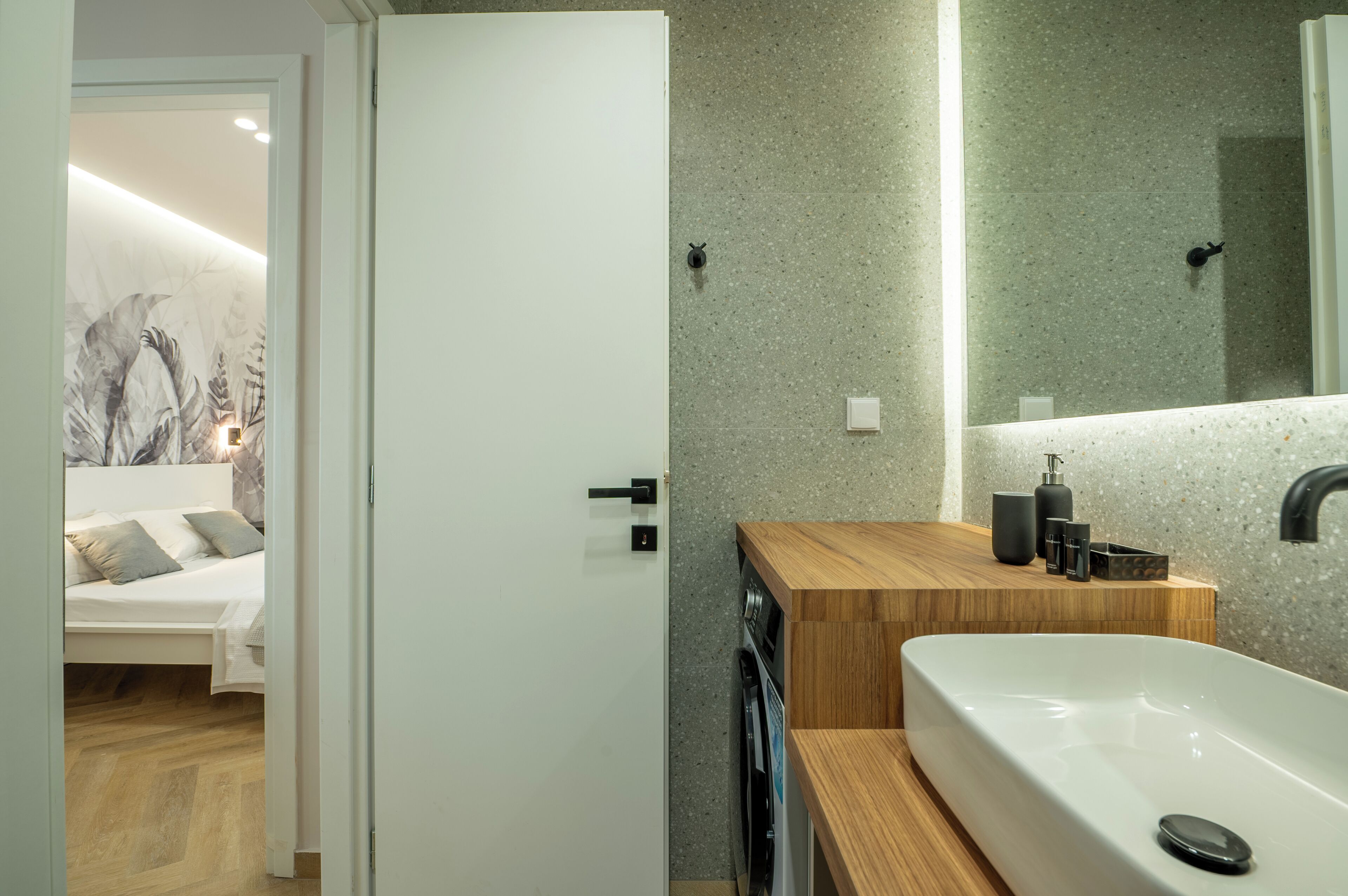 Un baño moderno con una bañera independiente, un tocador de madera y un espejo grande.