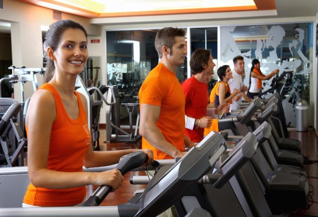 Une salle de sport équipée de tapis de course et d'appareils d'exercice.