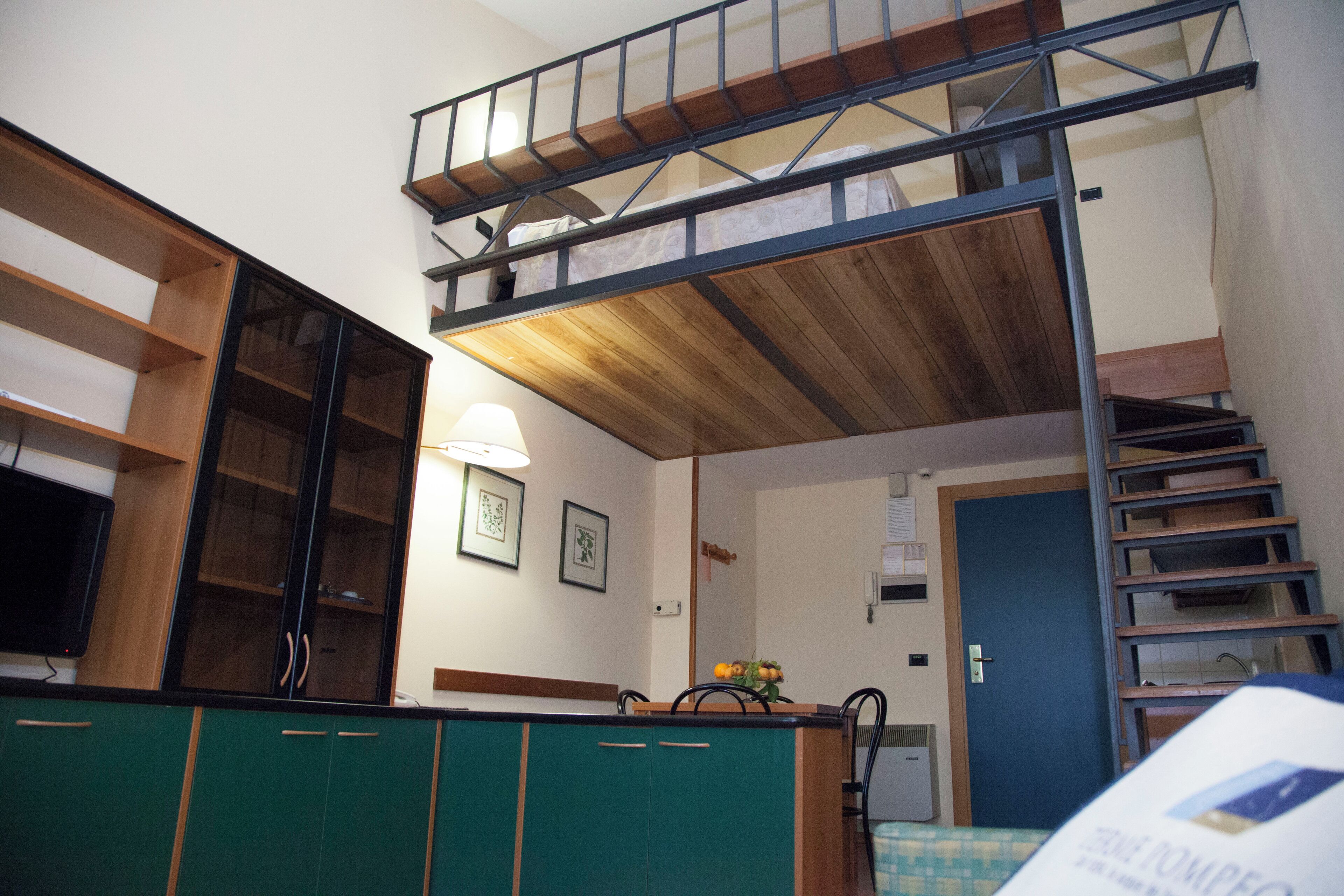 Una habitación pequeña con una litera, un kitchenette y una pequeña zona de comedor.