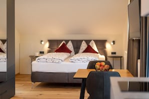 Une chambre à coucher moderne avec un lit, des tables de chevet et une table sur laquelle se trouvent des fruits.