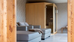 Un salon moderne comprenant un ensemble de canapés, une armoire en bois et une petite table.