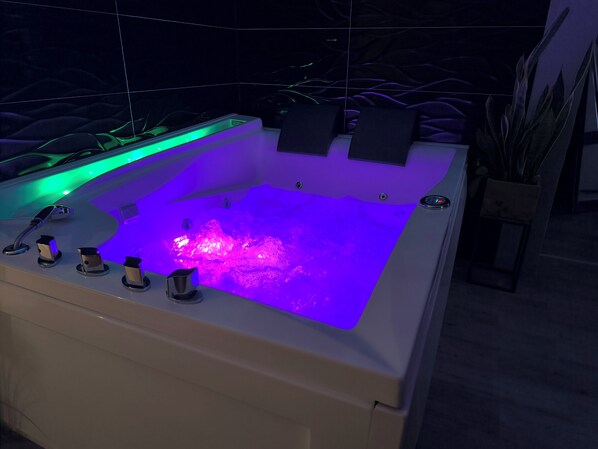 A modern spa tub with a built-in water feature and LED lighting. - Romantisches Ferienhaus Zeit zu Zweit (SA)