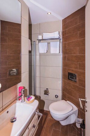 A modern bathroom with a white sink, a toilet, and a glass shower enclosure. - Cotton Boutique Hotel (Bodrum)