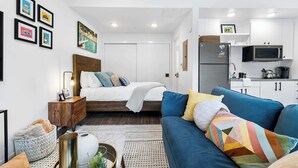 A compact living space with a bed, a sofa, a kitchenette, and a dining area. - Charming DT ATX Studio / Mins to Rainey St / Patio (Austin)