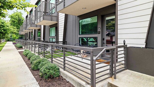 A modern building with multiple balconies, a concrete pathway, and a small garden area. - Charming DT ATX Studio / Mins to Rainey St / Patio (Austin)
