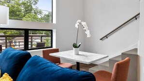 A modern interior with a sofa, a table with a potted plant, and a staircase. - Charming DT ATX Loft | Near Rainey St (Austin)