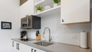 A modern kitchen with a stainless steel sink, a coffee maker, and a knife block.