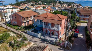Un quartier résidentiel où se trouve une maison remarquable, dotée d’un balcon, d’un petit jardin et offrant une vue sur la mer.