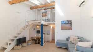 Un interior moderno con una escalera, un comedor, un sofá y una cocina.