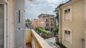A narrow street with buildings on either side, a balcony with a door, and a no parking sign. - Room 'Stanza Per 2 Persone' with Balcony and Wi-Fi (Genova)