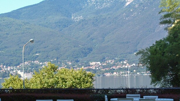 Terrasse extérieure avec vue sur une montagne et un lac.