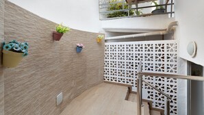 A modern interior with a wooden floor, a white wall with a textured pattern, and a white lattice partition. - Vacation Apartment 'Danoe 3' with Wi-Fi (Mogán)