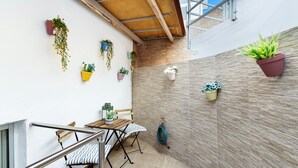 A balcony with a wooden table and chairs, potted plants, and a view of the sky. - Vacation Apartment 'Danoe 3' with Wi-Fi (Mogán)