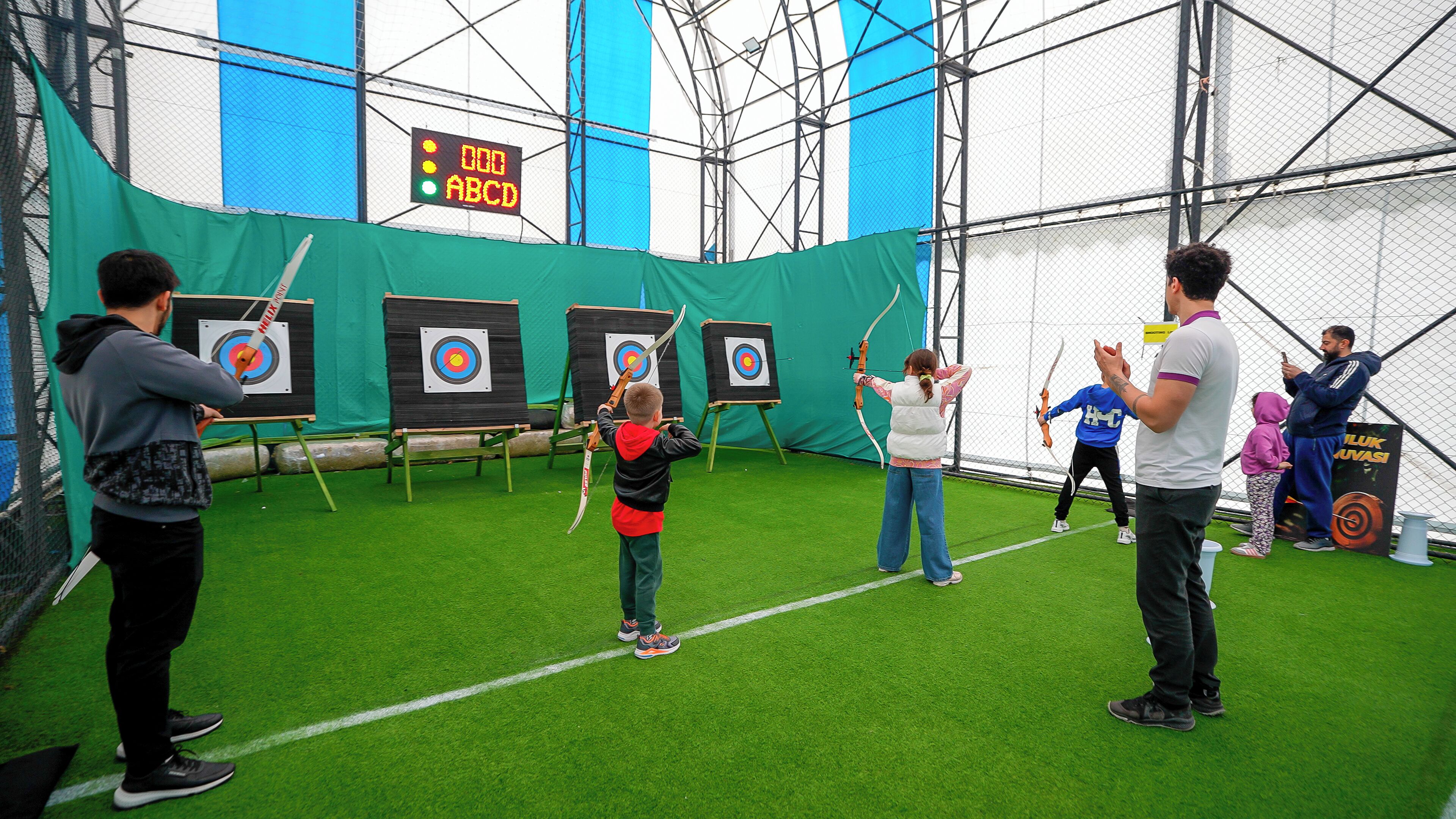 Un espai interior per practicar tir amb arc, amb objectius i participants.