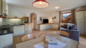 Una cocina moderna con comedor, televisor y sofá.