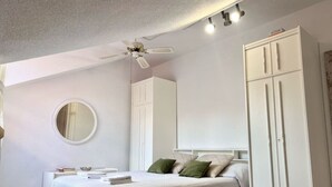 A bedroom with a bed, a wardrobe, a ceiling fan, and a mirror. - El Solsticio - 30601 (Somo)