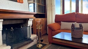 Una sala de estar acogedora con chimenea, un sofá y una mesa de centro.