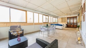 A spacious indoor area with a dining table, chairs, a sofa, and a large window. - 'Dante House' Apartment in the centre ideal for groups (Cagliari)