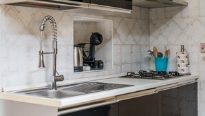 A modern kitchen with a stainless steel sink, a gas stove, and a built-in range hood. - 'Dante House' Apartment in the centre ideal for groups (Cagliari)