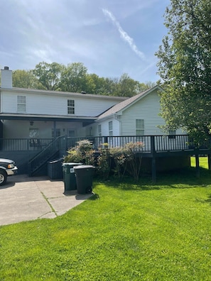A two-story house with a covered porch, a staircase leading to the upper floor, and a vehicle parked in front. - Spacious Hendersonville Home – Sleeps 7, Prime Location! (Hendersonville)