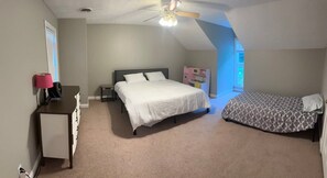 A bedroom with a bed, a desk, a chair, and a ceiling fan. - Spacious Hendersonville Home – Sleeps 7, Prime Location! (Hendersonville)