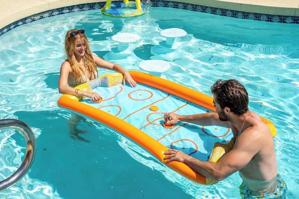 En swimmingpool med en vattenrutschkana och uppblåsbara leksaker.