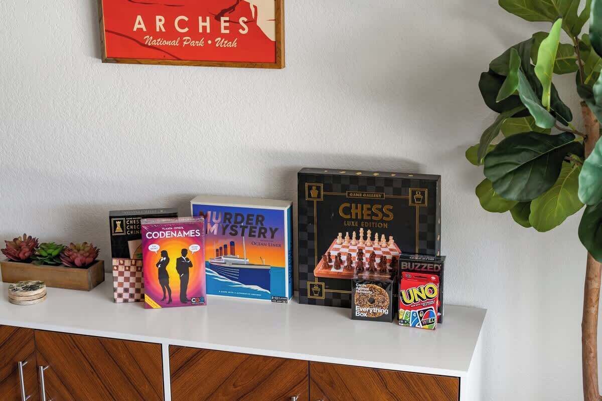 A shelf with board games including Chess, Murder Mystery, and UNO.