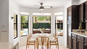 A modern kitchen with a dining area, large windows, and a view of an outdoor pool. - Sleeps 18 | Beautiful Resort Style | Heated Pool (Scottsdale)