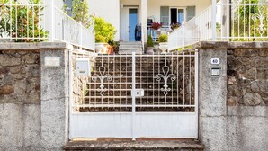 A gated entrance with a stone wall, a white gate, and a number '40' on the wall. - Villa La Lanterna Bianca Apartment with Mountain View, Wi-Fi, and Air Conditioning (Bagnone)
