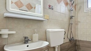 A bathroom with a sink, toilet, and shower. - Chariclia Hotel (Katerini)
