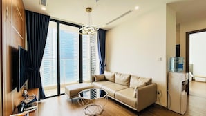 A modern living room with a sofa, a coffee table, and a water dispenser. - Mira Housing- Vinhome Skylake Luxury Apartment  (Hanoi)