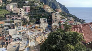 A coastal town with buildings on a hillside, overlooking the sea. - Stunning Sea View Apartment in the Heart of Riomaggiore (Riomaggiore)