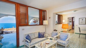 A room with a view of the sea, a sofa, a chair, a table, and a lamp. - Villa Majus - with swimming pool and direct access to the sea in marine protected area  (BAGHERIA)