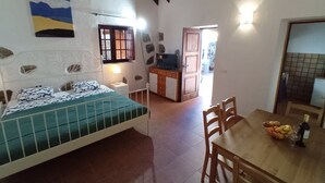 A bedroom with a bed, bedside table, and a view of the dining area. - Finca La Sirena Vacation Apartments - Apt. # 9 Garachico (San Juan del Reparo)