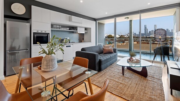 Un apartamento moderno con cocina, comedor y balcón con vistas a la ciudad.