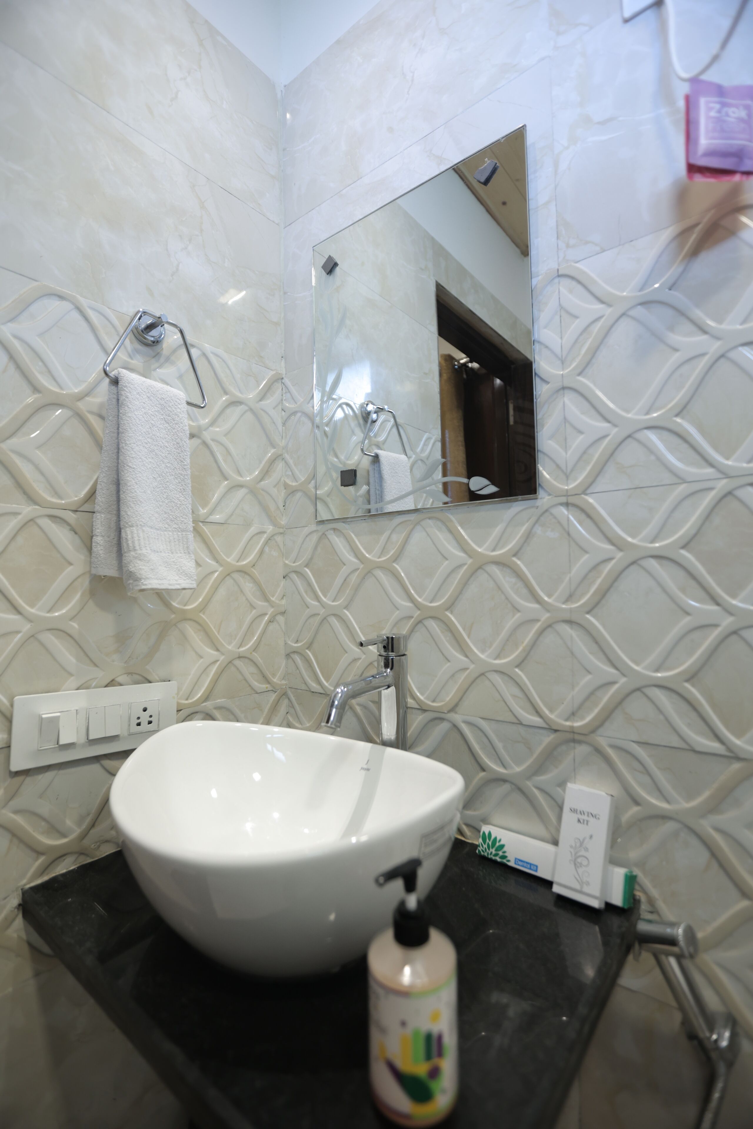Ein Badezimmer mit einem weißen Waschbecken, einem Spiegel und einem Handtuch an einem Haken.